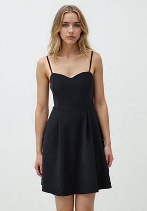 Zwarte mouwloze jurk met een hartvormige halslijn, een getailleerde corsage en een uitlopende rok. Gemaakt van gladde stof met dunne bandjes.