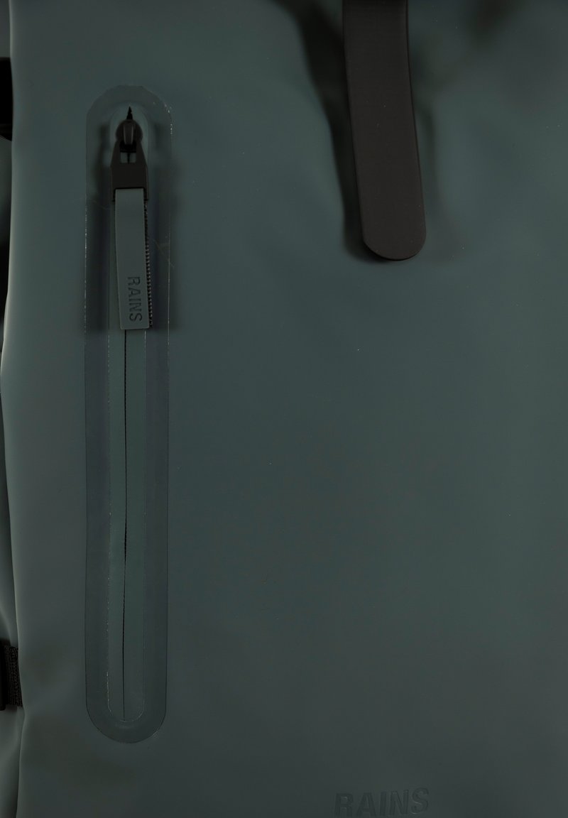 Dunkelgrüner wasserdichter Rucksack mit glatter Textur, seitlicher Reißverschlusstasche mit Branding-Element und kontrastierenden schwarzen Hardware.
