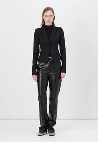 Black tailored blazer and fitted black leather pants. Blazer has a single button closure and elongated sleeves. Smooth leather texture with a sheen.