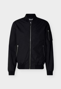 Veste bomber noire avec fermeture éclair avant, poches latérales zippées, poche zippée sur la manche, poignets et col côtelés, présentée sur un fond uni.