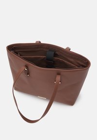 Brązowa torba tote z teksturowanej tkaniny, z dwoma ramiączkami, otwartym górnym zamknięciem, wewnętrzną wyściełaną przegrodą na laptop oraz czarnym paskiem zabezpieczającym.
