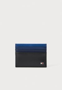 Kártyatartó függőleges bordázott mintázattal, sötétkék és fekete színekben. Öt rekesszel rendelkezik és egy kis logó akcentus található az elülső oldalon.