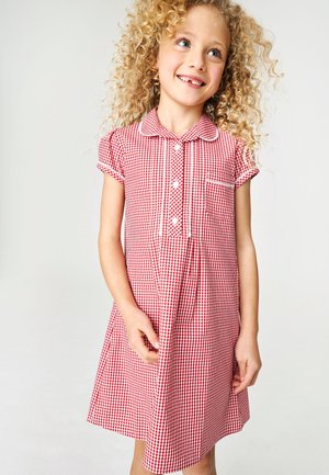 Czerwona i biała sukienka w kratkę gingham, z krótkimi rękawami, kołnierzykiem, zapięciem na guziki z przodu oraz małą kieszonką na piersi.
