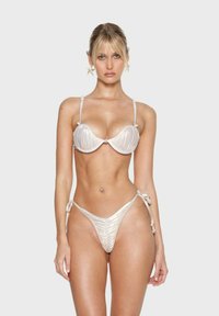 Lichtbeige bikini met gestructureerde, geraffineerde stof; onderbroken bh-top met verstelbare bandjes en een Braziliaanse stijl onderkant met strik zijkanten.
