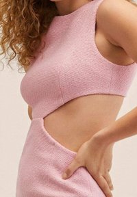 Robe rose texturée avec un design à découpe, comprenant un haut sans manches et une silhouette ajustée. Remarquable pour son tissu tissé et sa forme unique.