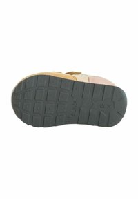 Sole della scarpa in gomma nera testurizzata, con un motivo di trazione e marchio in rilievo; i colori includono accenti beige e rosa chiaro.