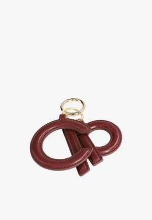 Sleutelhanger met donkerrode leren letters "C" en "P" bevestigd aan een gouden metalen ring op een witte achtergrond.