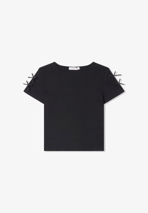 Top corto nero a maniche corte con scollatura rotonda e tessuto testurizzato. Presenta nastri neri decorativi alle cuciture delle maniche.