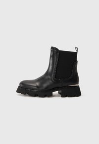 Stivaletto in pelle nera con suola chunky, pannello laterale elasticizzato, linguetta per il tallone e rifiniture decorative lungo gli orli e la suola.