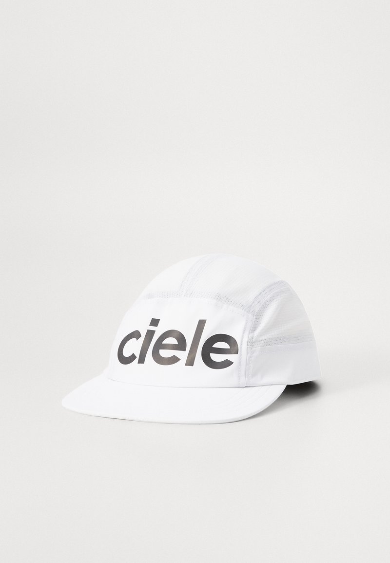 White running cap with black "ciele" logo, made of lightweight material. Features a curved brim and breathable mesh panels on the sides.
