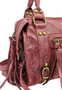 Sac à main en simili cuir rouge avec quincaillerie en laiton, plusieurs zips et détails en franges. Forme compacte avec surface texturée.
