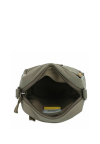 Bolso de hombro de tela verde con cierre de cremallera, que cuenta con un bolsillo interior y una etiqueta de acento amarilla. Textura suave y forma rectangular.