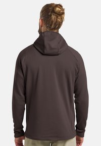 Giacca con cappuccio marrone, caratterizzata da un motivo testurizzato, maniche lunghe e dettagli di cucitura piatta, progettata per comfort e funzionalità.