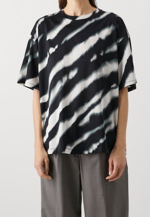 Svart och vit tie-dye oversized t-shirt med korta ärmar och rundad halsringning, med vågiga mönster och en avslappnad passform.