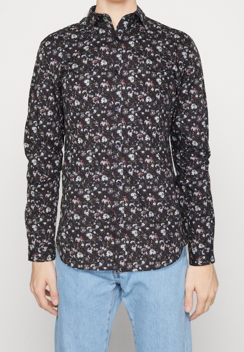 Camicia nera con bottoni dallo schema floreale in tonalità bianche, rosse e blu. Presenta un colletto classico e maniche lunghe con orlo curvo.
