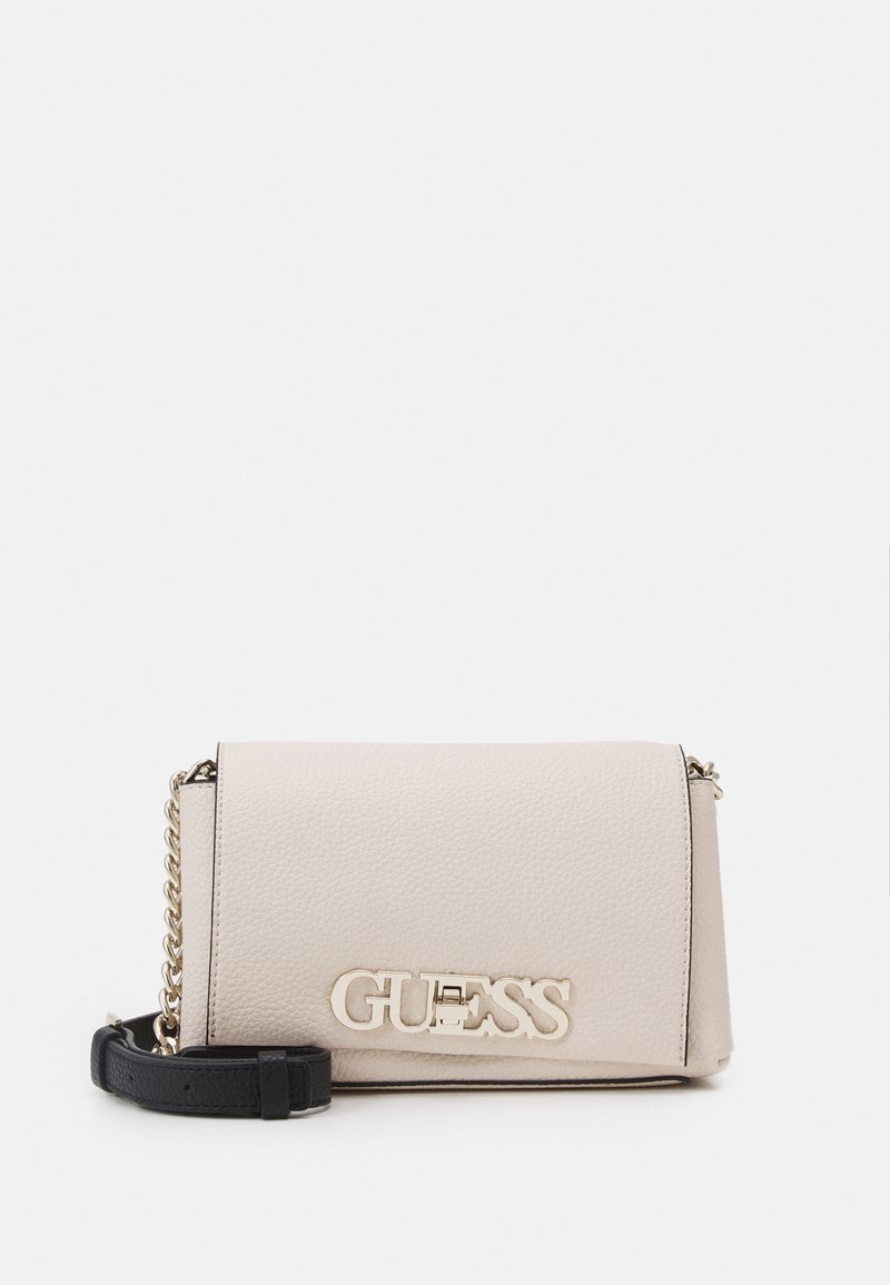 Beżowa skórzana torebka crossbody o teksturowanym wykończeniu, z złotym logo i odpinanym czarnym paskiem. Prostokątna forma, zamek błyskawiczny.
