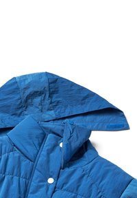 Blå isolerad jacka med huva, med en kviltad textur, tryckknappar och kardborreaccents. Materialet verkar lätt och mjukt.