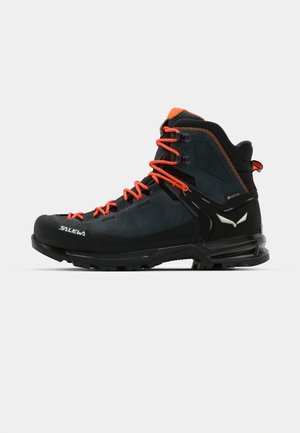 Black and orange hiking boot featuring a suede and textile upper, reinforced toe cap, and a rugged rubber sole with deep treads.