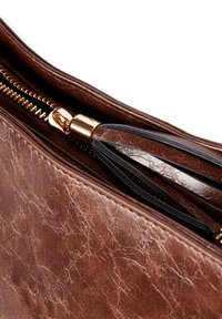 Brązowa torebka kopertówka z teksturowanej skóry z złotym zamkiem błyskawicznym i czarnym uchwytem. Wnętrze ma uporządkowane przegrody i podszycie.