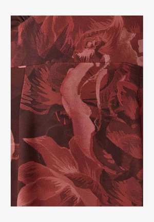 Rood stof met bloemmotief in verschillende tinten bordeauxrood en roze. Kenmerkt zich door gedurfde bloemvormen en een zachte, gladde textuur.