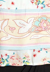 Látka s květinovým vzorem, která má krémový podklad s růžovými, modrými a zelenými motivy. Hladká textura a viditelné vrstvené části.