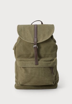 Sac à dos en toile vert olive avec poche avant et fermeture à boucle en cuir marron sur fond uni.