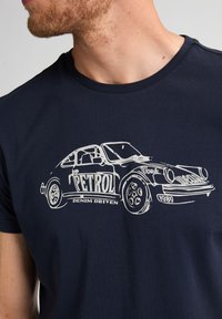 Námořnická modrá tričko s bílou grafikou vintage auta a texty "PETROL" a "DENIM DRIVEN", kulatý výstřih a krátké rukávy.
