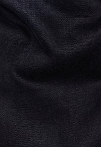 Svart denimtyg med en slät textur och subtil lyster, kännetecknat av sin täta väv och minimala elastik. Inga mönster eller accentuerande detaljer.