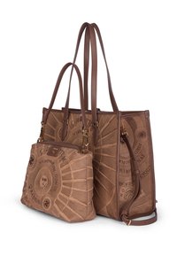 Bruine stoffen tote bag met een textuurdesign, voorzien van een ingewikkeld cirkelpatroon en een kleinere bijpassende tas die is bevestigd met een gouden sluiting.