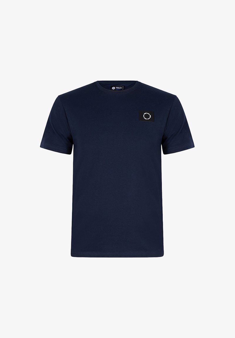 T-shirt bleu marine à manches courtes en coton. Présente un patch carré noir avec un motif circulaire blanc sur la poitrine gauche. Col rond.