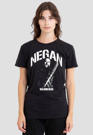 Young woman wearing black T-shirt with a graphic of Negan holding a barbed wire bat from The Walking Dead.