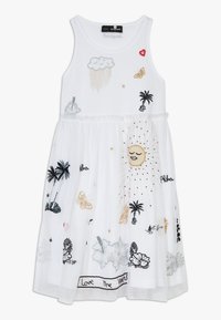 Biała sukienka bez rękawów z kolorowymi haftowanymi wzorami chmur, motyli, słońca, palm i napisu wzdłuż dołu.