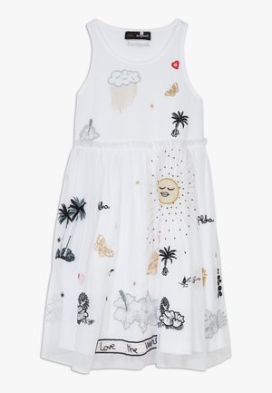 Witte mouwloze jurk met kleurrijke geborduurde ontwerpen van wolken, vlinders, de zon, palmbomen en tekst langs de zoom.