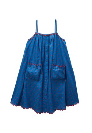 Robe bleue sans manches à pois rouges, boutons sur le devant, deux poches avant et bords festonnés avec un liseré rouge.