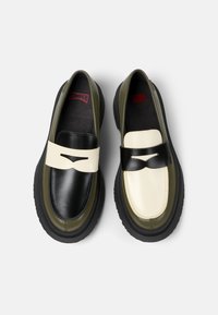 Černé a krémové loafers s zelenými akcenty; hladká kožená svrchní část, masivní černá gumová podrážka, dekorativní páska přes nárt.