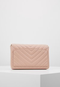 Borsa a tracolla trapuntata rosa con motivo a zigzag, texture liscia e tasca frontale. Forma rettangolare compatta con angoli arrotondati.