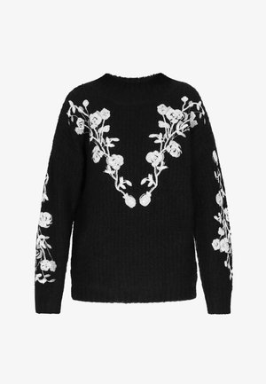 Fekete kötött pulóver fehér virágos hímzéssel a nyakvonalon és az ujjakon. Puha tapintású és laza fazonú.
