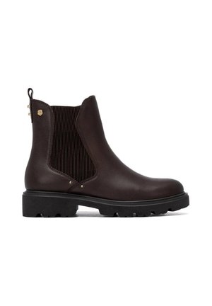 Bota Chelsea de cuero marrón oscuro con paneles laterales elásticos negros, lengüeta de tirador en el talón, suela gruesa con tacos y pequeño detalle de logo metálico dorado cerca del tobillo.