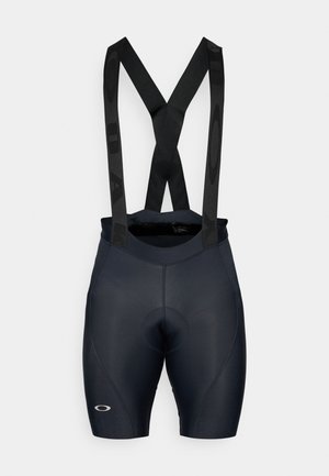 Black cycling bib shorts with adjustable straps, padded seat, textured fabric, and logo detail on the left leg. Form-fitting design.