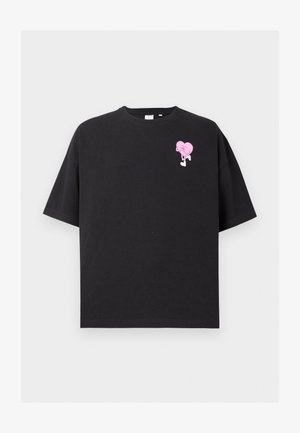 Must have särk, mis on valmistatud puuvillast, musta värvi ning sellel on vasakul rinnal roosa südame graafika koos jalgadega. Lühikesed varrukad ja lõdvestatud istuvuse disain.