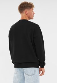 Johnny Urban CARTER OVERSIZED CREWNECK - Felpa - schwarz logo print