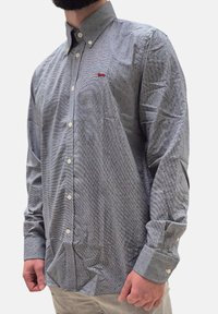 Camicia a maniche lunghe con bottoni, blu e bianca, con un motivo testurizzato e dettagli rossi, dotata di colletto alla francese e bottoni bianchi.