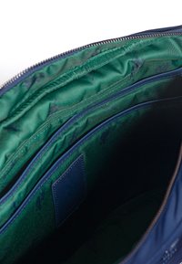 Marinblå väska med slät yta och grönt tyginteriör. Har flera fack och dragkedja. Rektangulär form.