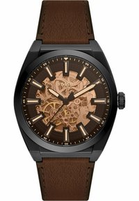 Montre avec bracelet en cuir marron, boîtier noir, mouvement squelettique et cadran marron. Les marqueurs sont de couleur claire avec des chiffres arabes à intervalles.