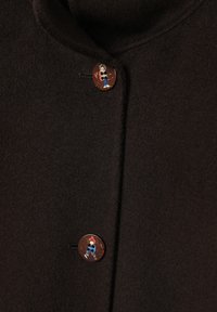 Barna gyapjúkabát magas gallérral, díszes gombokkal, melyeken rajzfilmfigurák láthatók, valamint puha, texturált szövetszövettel.