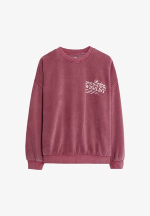 Sudadera burdeos de tela suave, con un escote redondo y puños de canalé. El texto en el frente dice "Pendiente: Lista de deseos de destino".