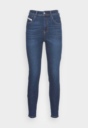 Mørkeblå høy midje skinny jeans med frontknapp, glidelås-lukking og fem lommer med kontrastsøm på hvit bakgrunn.