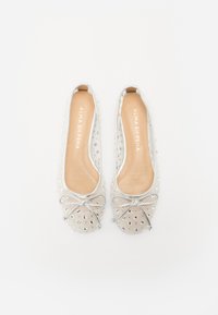Ballerine trasparenti con accenti argentati, motivo a pois, dettaglio a fiocco sulla punta e una suola interna liscia beige.