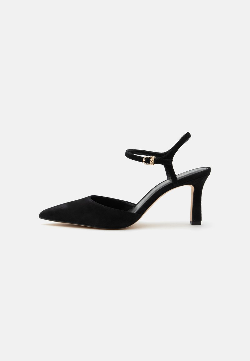Chaussure à talon haut en daim noir avec bout pointu et fine bride chevillère avec une petite boucle dorée.