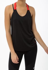 Musta urheilullinen tanktoppi, jossa on punaiset hihnat, valmistettu kevyestä kankaasta. Ominaisuuksiin kuuluu pyöreä pääntie ja rento malli, yhdistettynä mustiin legginsseihin.